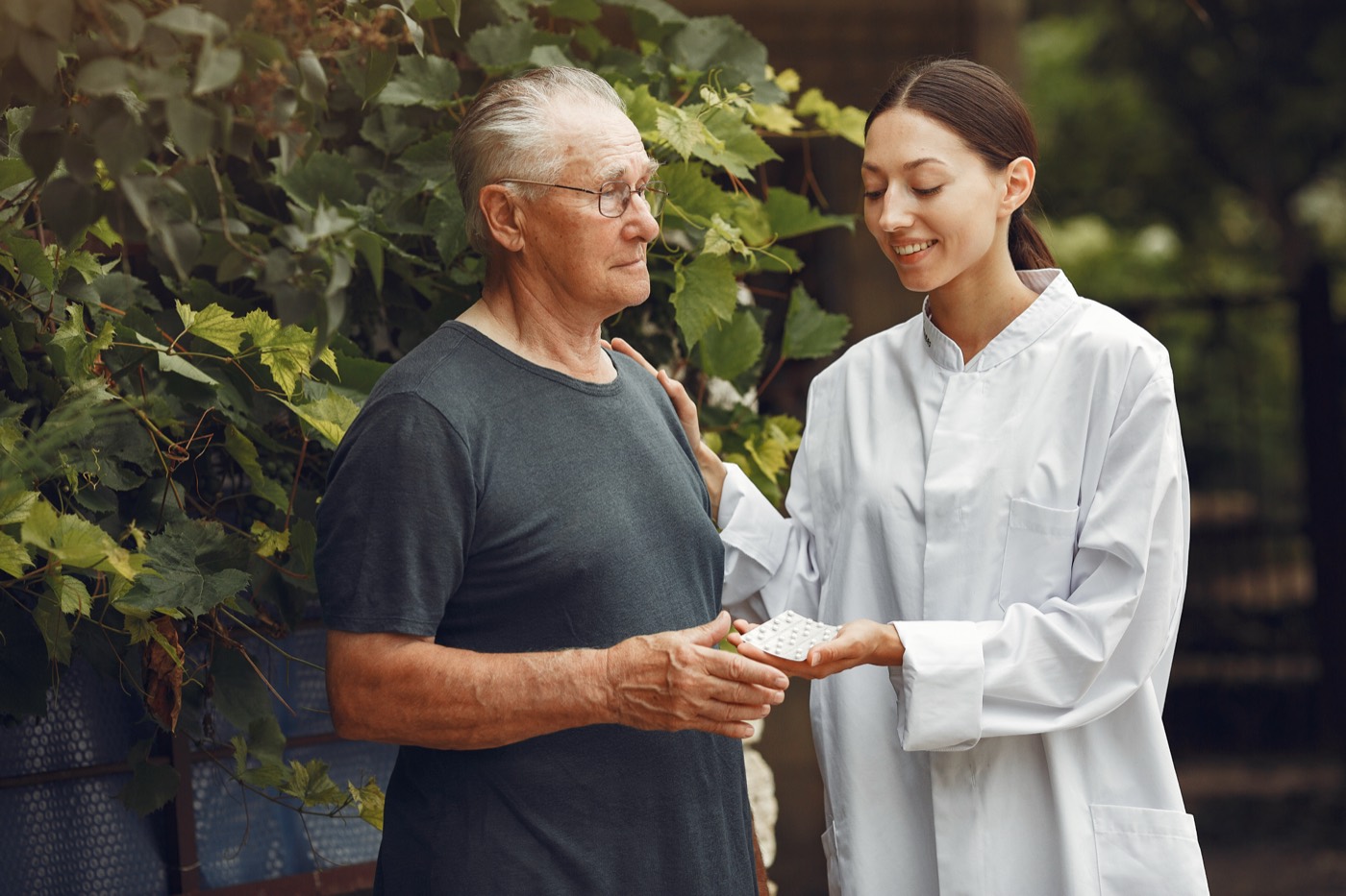 Caregiver reading with elderly patient
